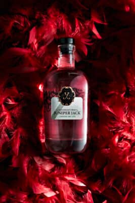 Juniper Jack London Dry Gin Flasche in roten Federn